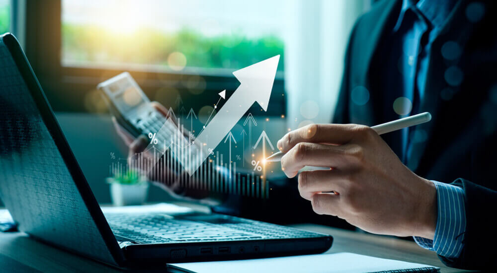 The image showcases a business professional working with financial data, symbolized by a digital arrow graph signifying growth and improvement. This visual represents the capabilities of Prima Consulting's Delta IFRS 17 Software, particularly its Comprehensive Accounting Module. The module ensures IFRS 17 compliance, manages corporate ledgers with a flexible chart of accounts, and supports real-time decision-making. It allows the generation of management reports, complete financial statements, and general ledger statements with instant P&L and balance sheet updates, offering a holistic view of financial health and unparalleled control.