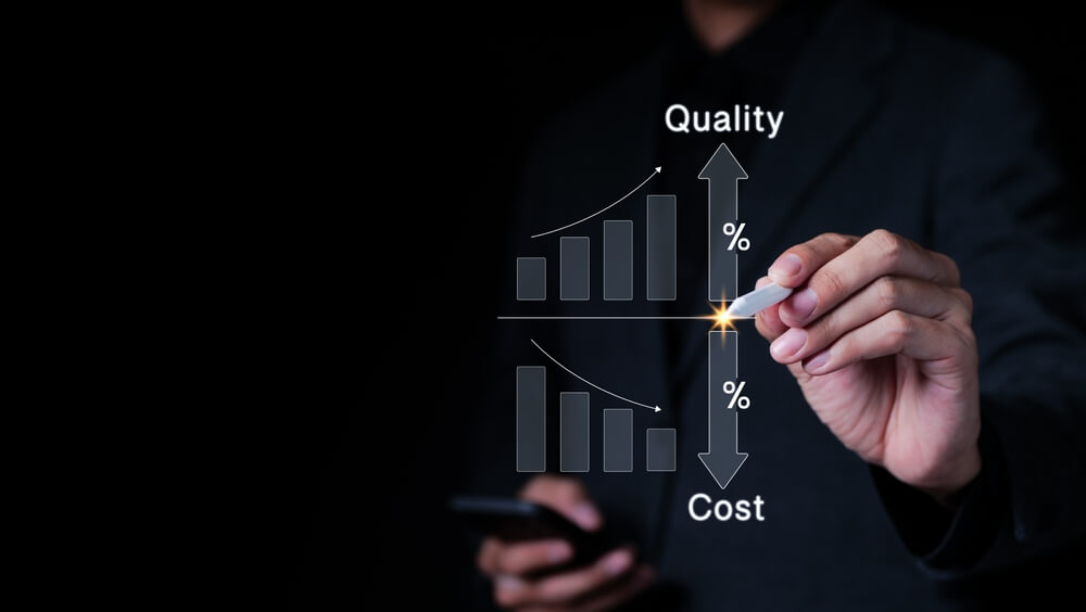 A person in a suit is holding a smartphone in one hand and using a stylus to draw on a virtual screen with the other hand. The screen displays two bar graphs with arrows indicating trends. The top graph shows an upward trend labeled "Quality," while the bottom graph shows a downward trend labeled "Cost." The image represents the concept of Digital Operations Optimization, highlighting the relationship between improving quality and reducing costs.