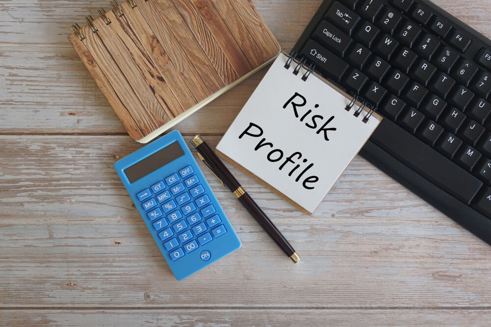 Entity Risk Profiling: A desk with a keyboard, notebook, pen, and calculator, highlighting the importance of risk profiling in business.