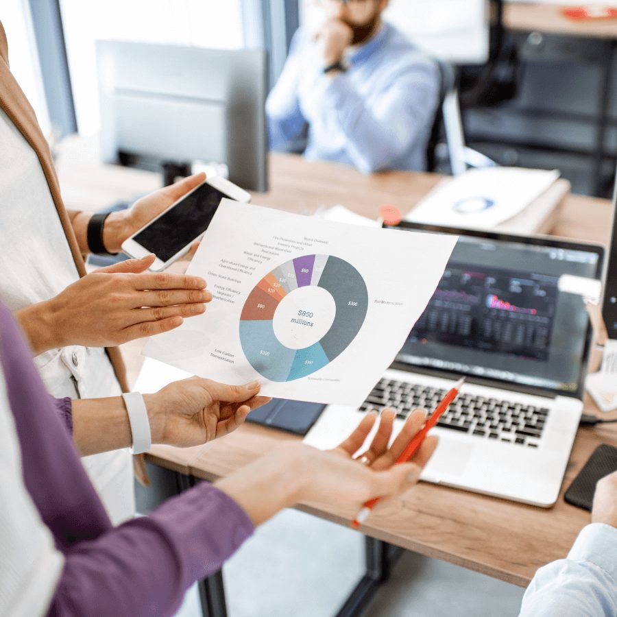 Professionals reviewing a financial chart and data on a laptop, showcasing expertise in Financial Planning and Analysis.