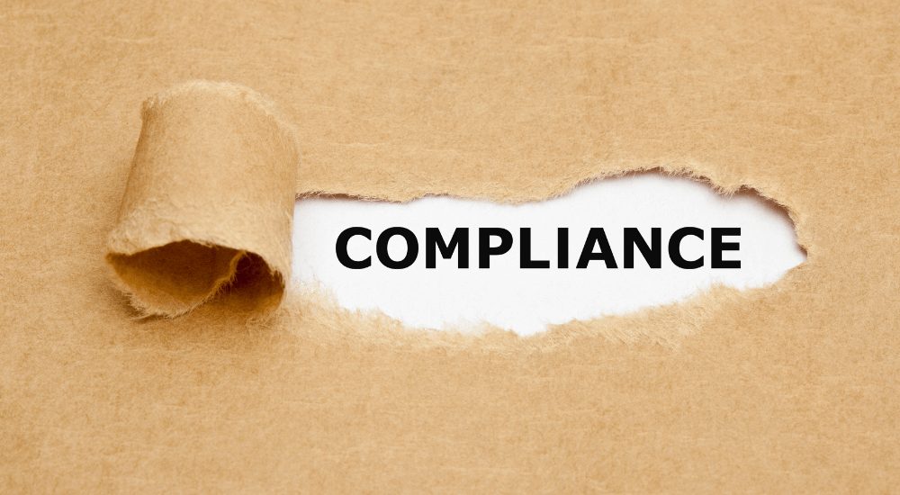 The word "COMPLIANCE" exposed under torn paper, symbolizing ARK9 EIR IFRS 9 compliance software's role in meeting heavy governance requirements.