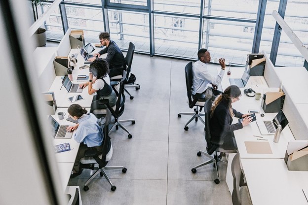 Overhead view of a team working on IFRS 16 advisory at office desks with laptops, notebooks, and office supplies in a collaborative workspace.