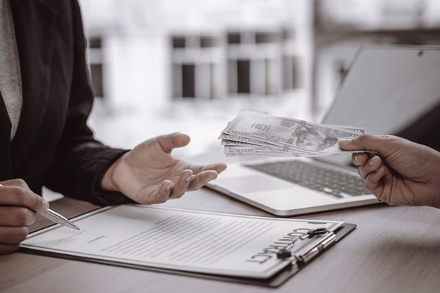 A business transaction with a contract and money exchange, highlighting the financial agreements governed by IFRS 17 standards.