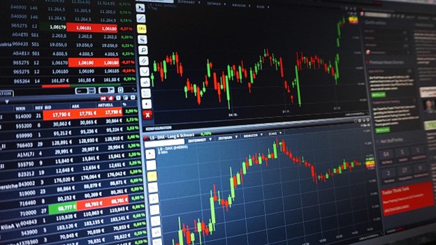 A close-up view of a computer screen showing financial trading charts with red and green candlesticks and numerical data, representing the outputs and market data that an IFRS 17 Calculator helps insurance companies analyze.