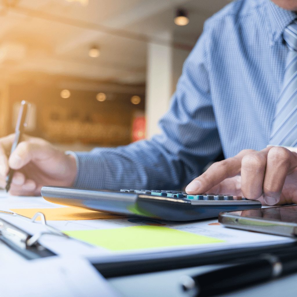 Finance professional using calculator for lease accounting calculations with IFRS 16 advisory services documentation.